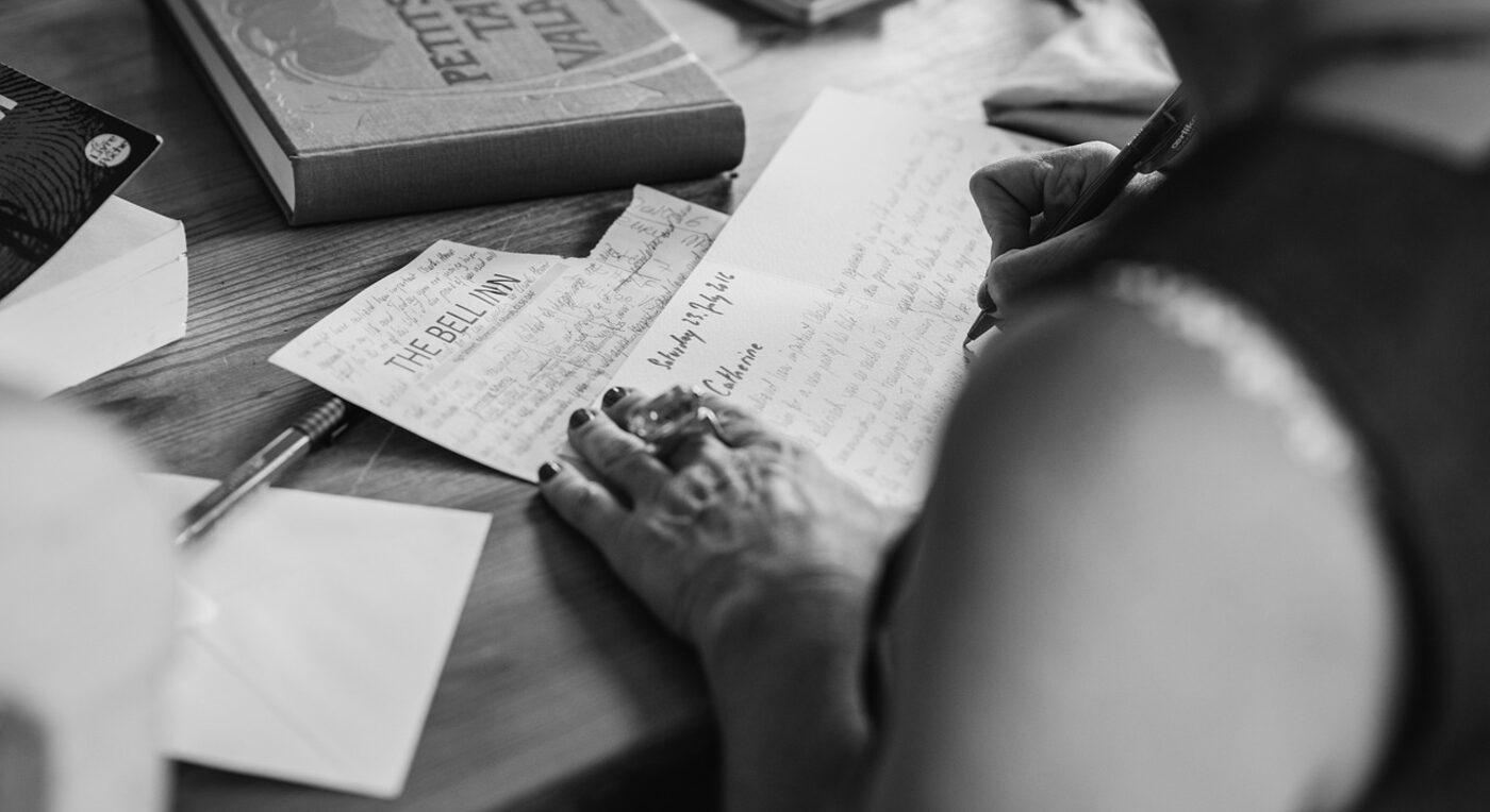A handwritten timesheet and pen on a desk — manual tracking relies on memory and end-of-day reconstruction