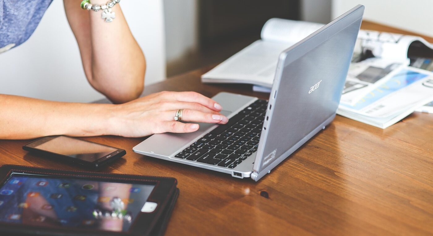 Hands typing a message on a laptop — a default invoice message saves rewriting the same note every billing cycle